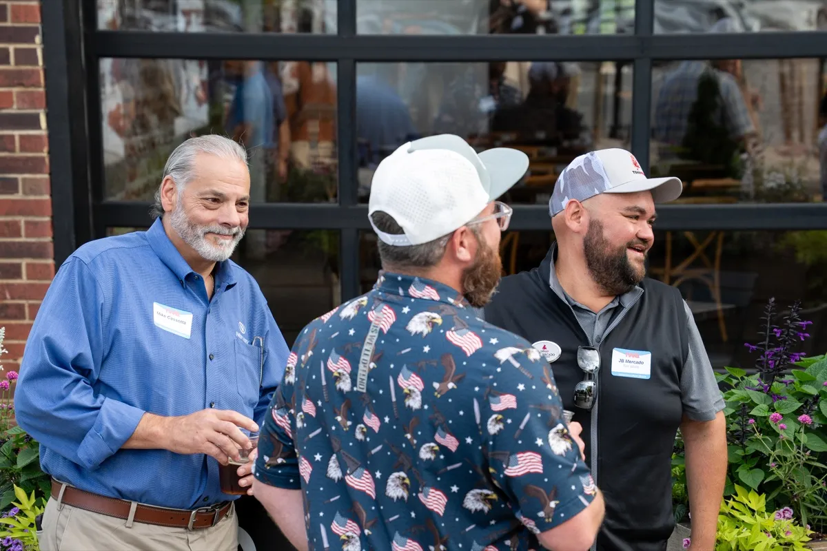 Three attendees laughing outdoors at the kickoff