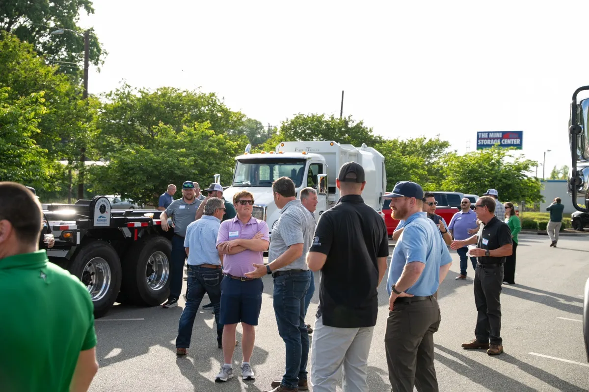 Garbage trucks and attendees in the kickoff parking lot